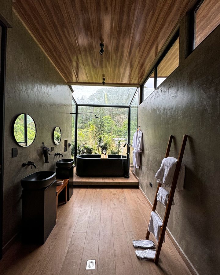 Baño de Lord S. Ville con tina en cubículo de vidrio frente a la montaña