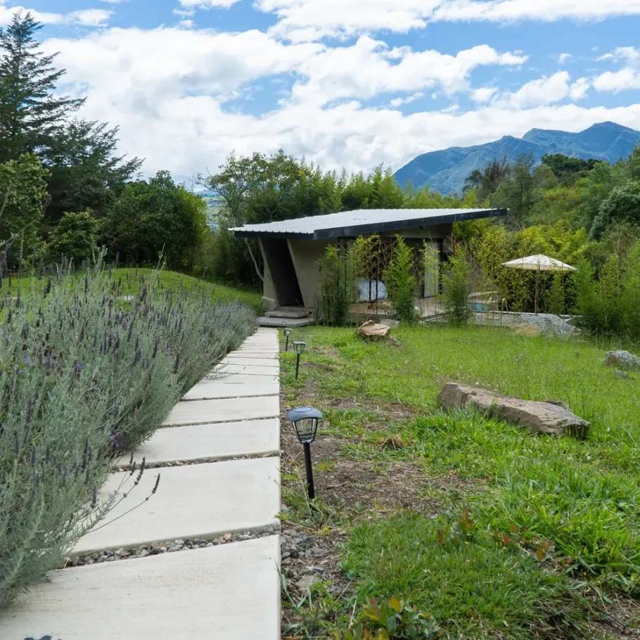 Villa de AlmazewÁ entre jardines de lavanda y plantas nativas, con el cerro Güinto al fondo